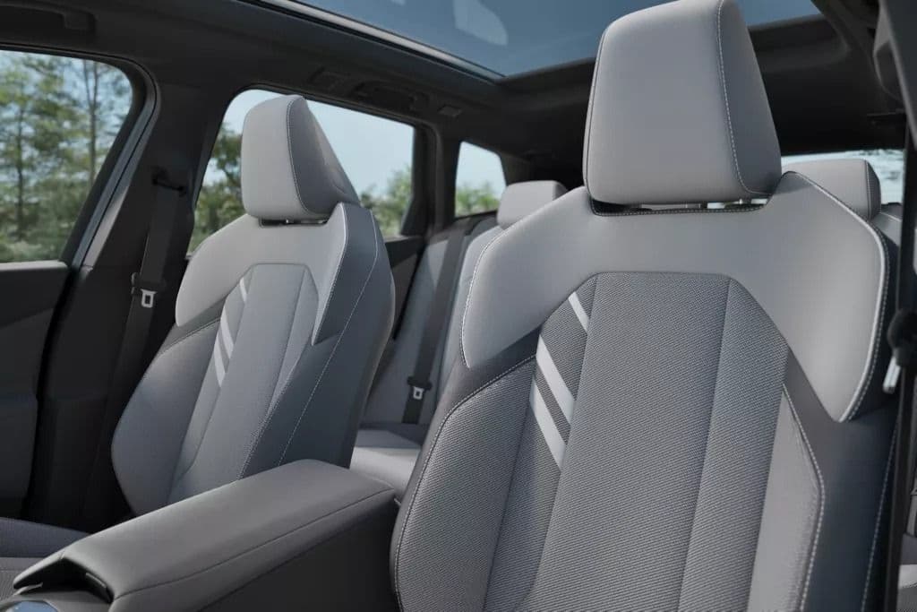 Front seats of a modern car interior with gray fabric and white accent stripes.
