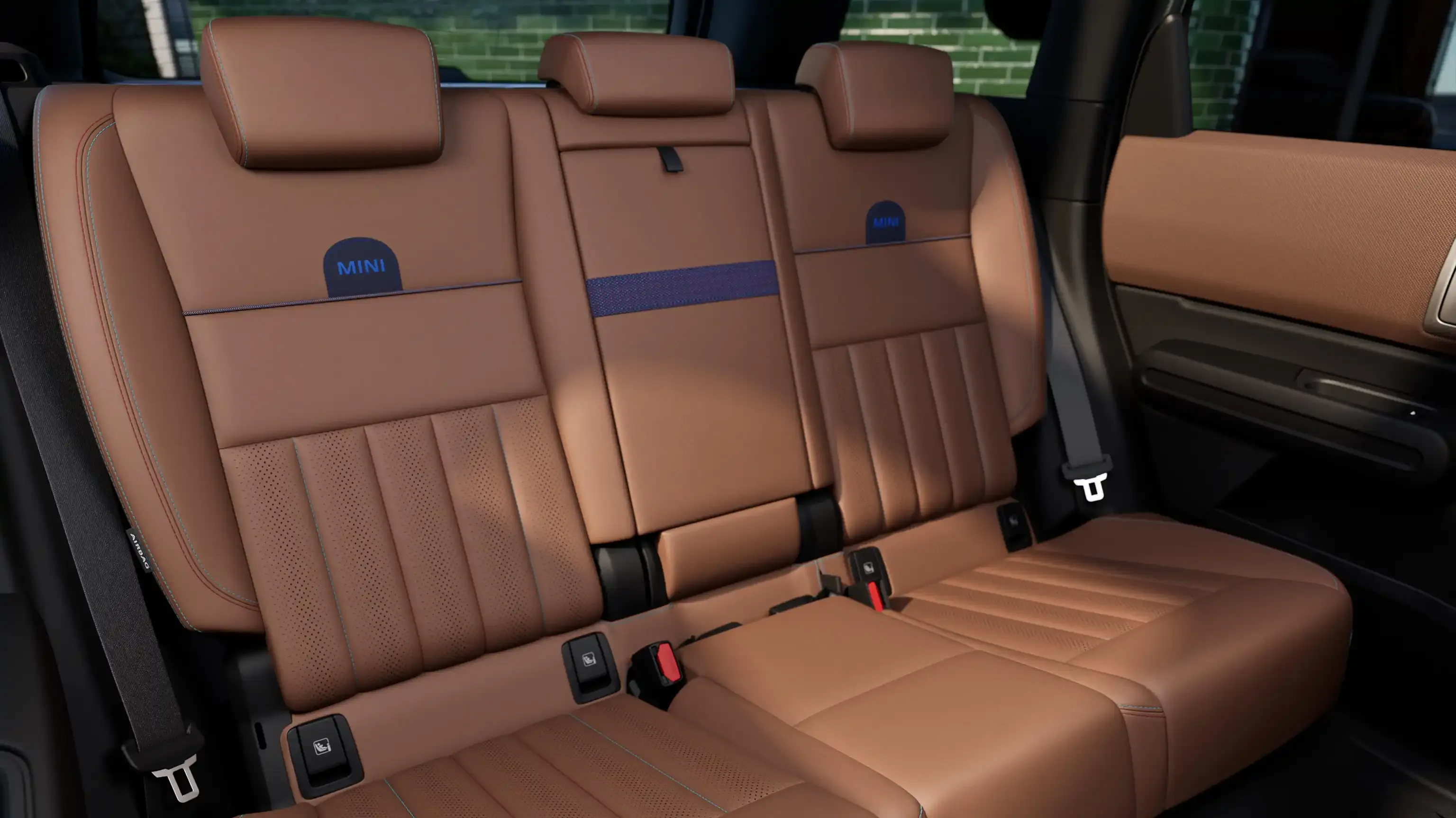 Luxurious brown leather rear car seats with blue stitching and headrests.