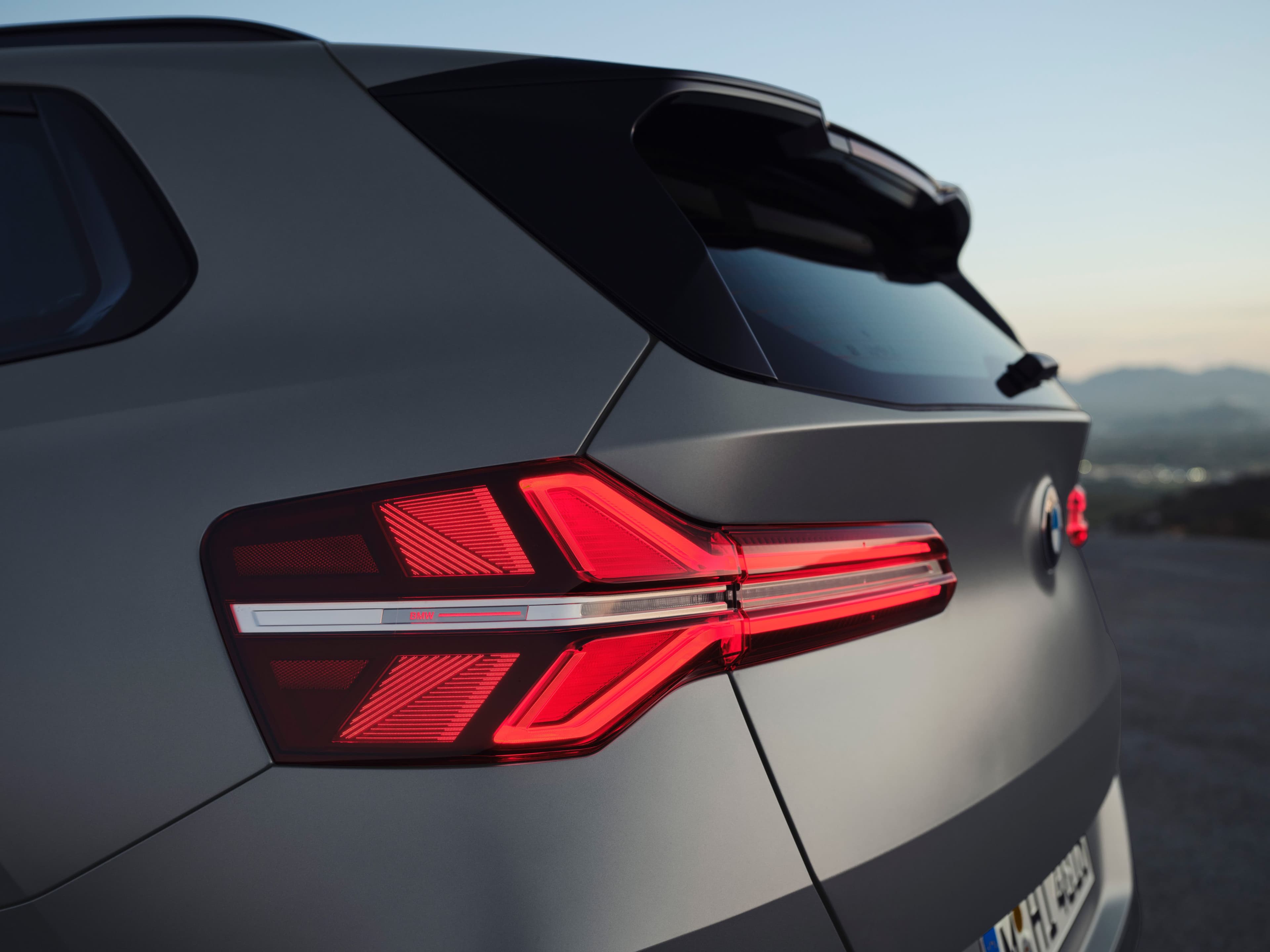 Close-up rear view of a modern gray SUV's illuminated taillight.